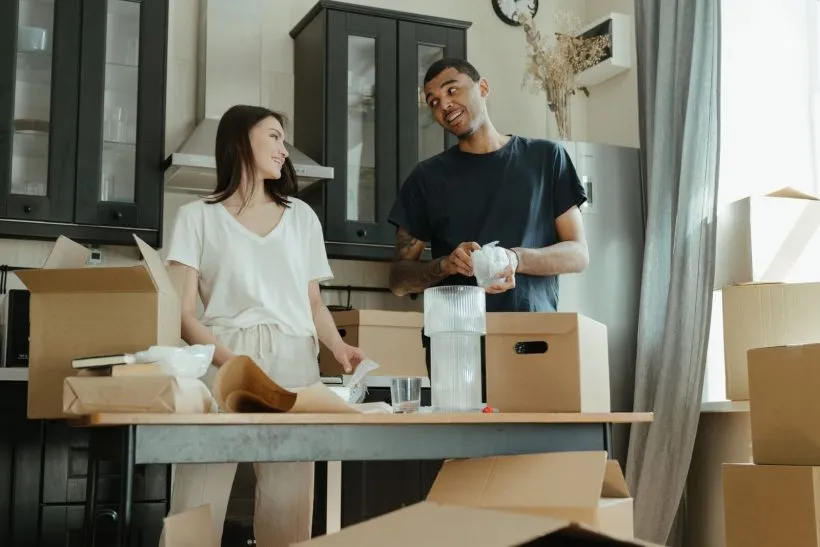 Couple unpacking boxes in the kitchen of their new home